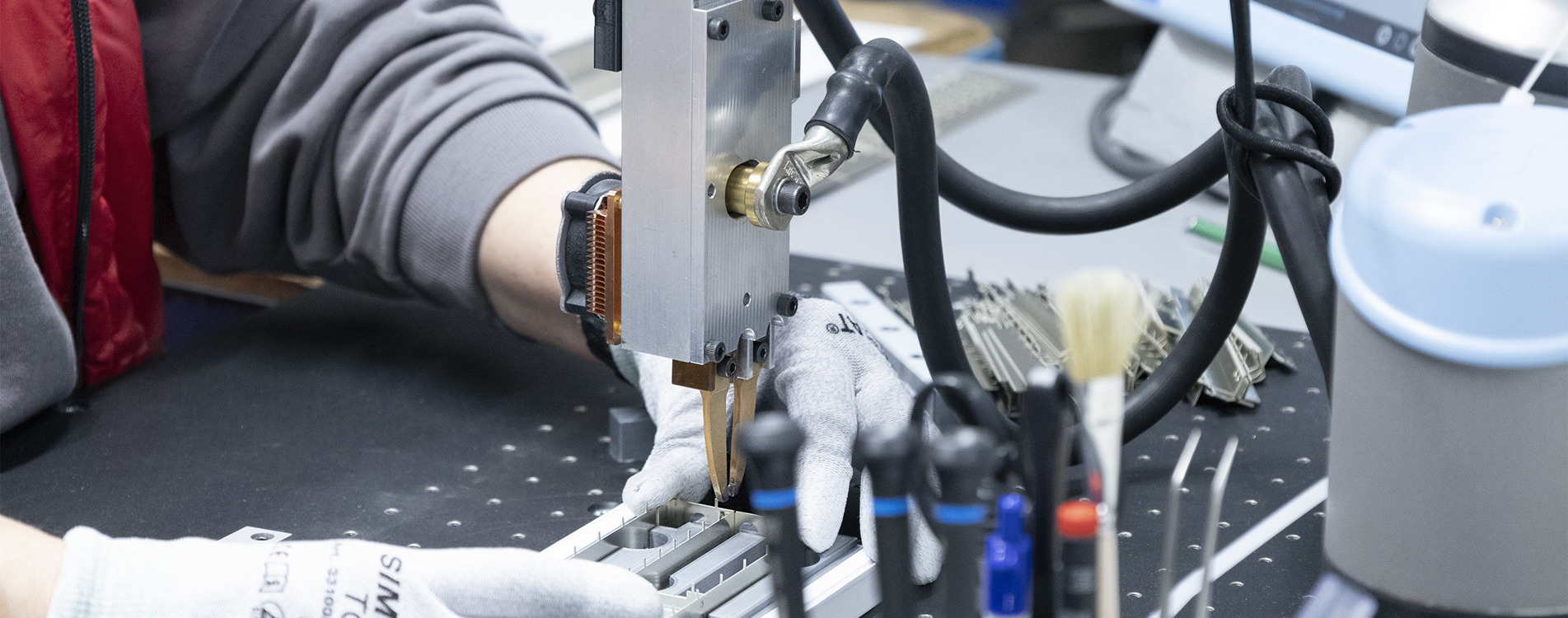 Arbejder med cobot til fleksibel automation, optimering og produktivitet inden for metal og elektronik.