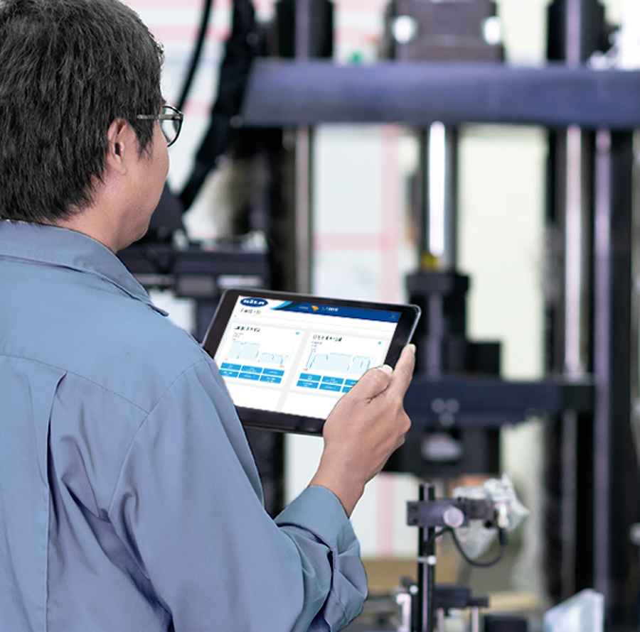 Arbejder med briller, der tjekker data og grafer på en tablet i produktionen