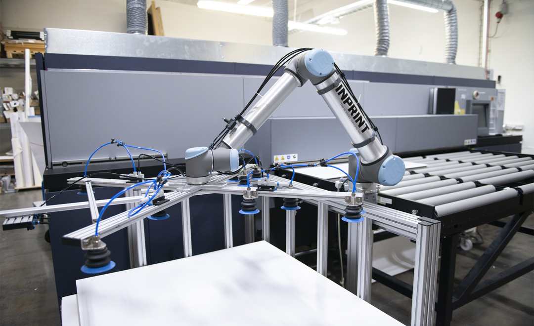 UR10-robotarm griber plader og flytter dem til printeren hos InPrint